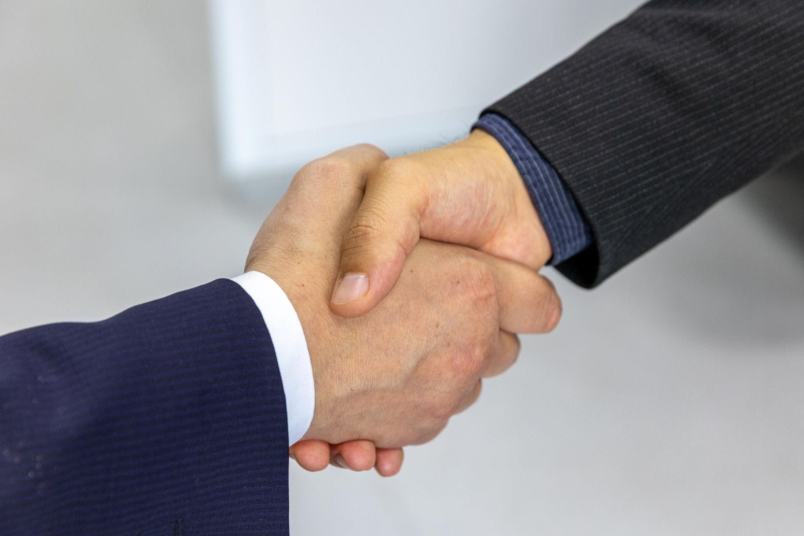 Two people shaking hands across a table after agreeing on wedding vendor terms
